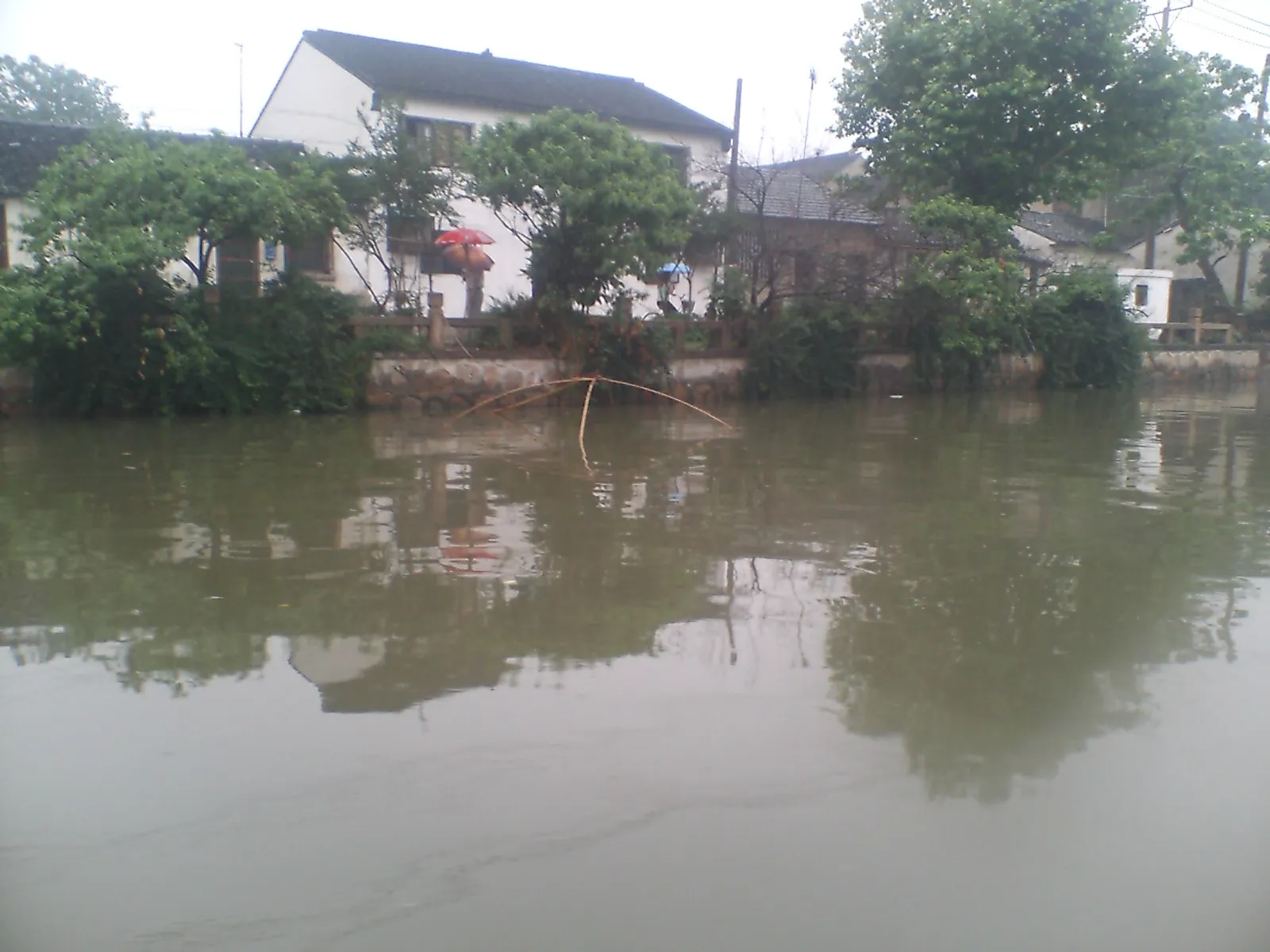 蘇州観光　蘇州の小雨の降る運河を遊覧船はどんどん進む。乗客2名