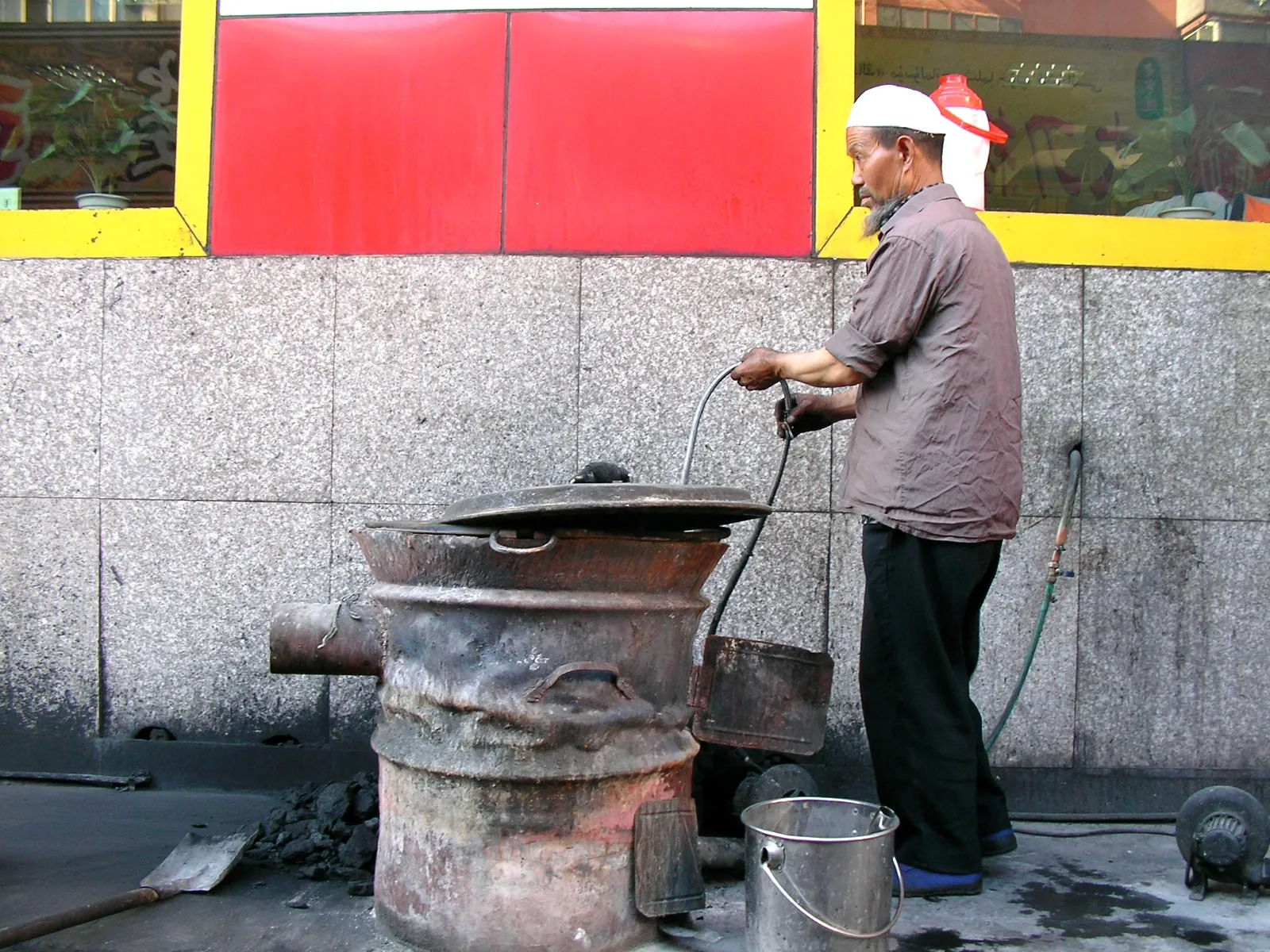 古い炭焼きコンロとウイグル族のおじさん