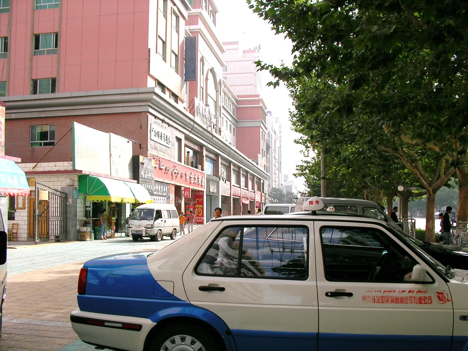 阿克蘇国際大酒店の側の街路樹とタクシー