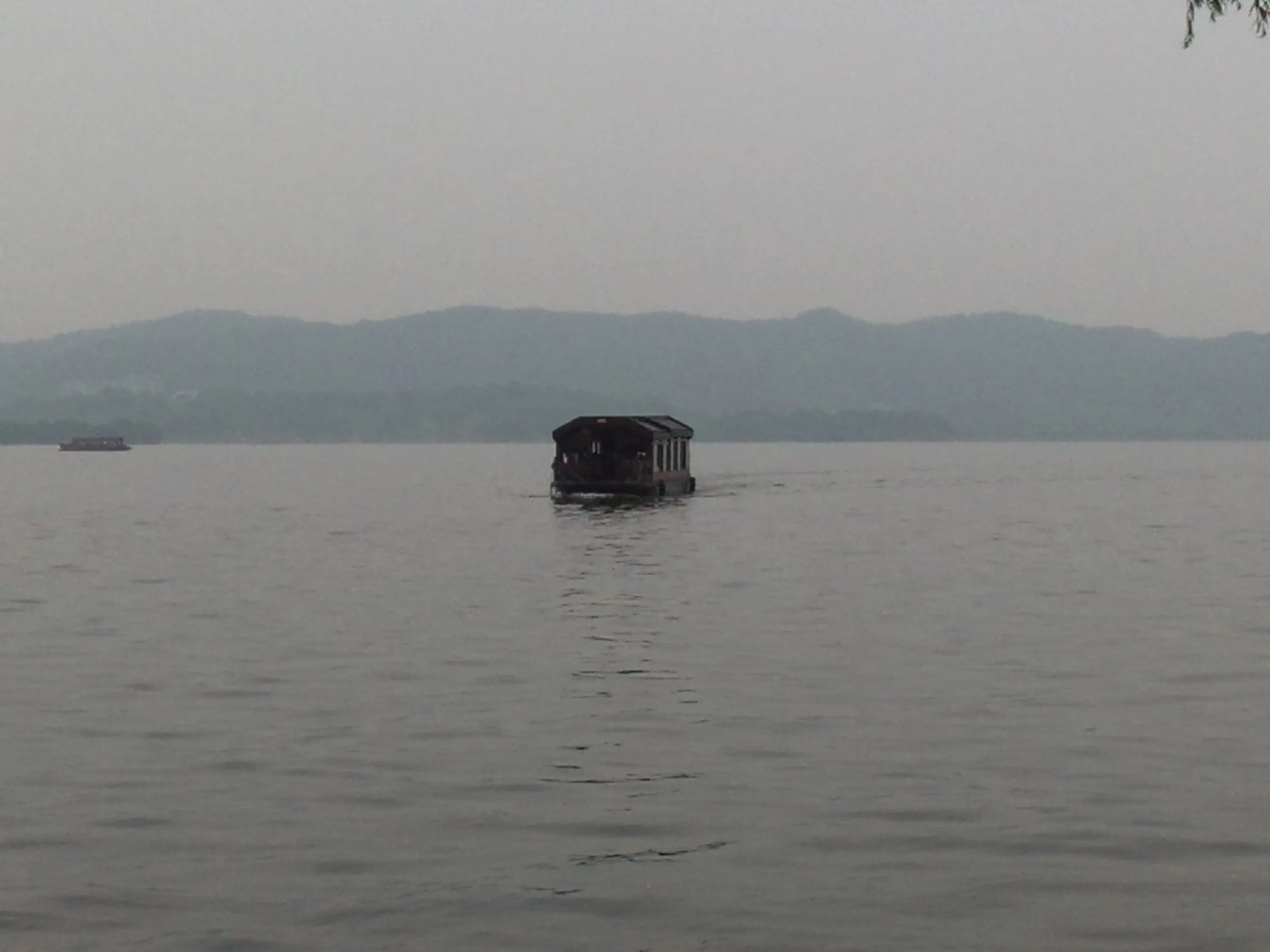 西湖湖畔から船を眺める