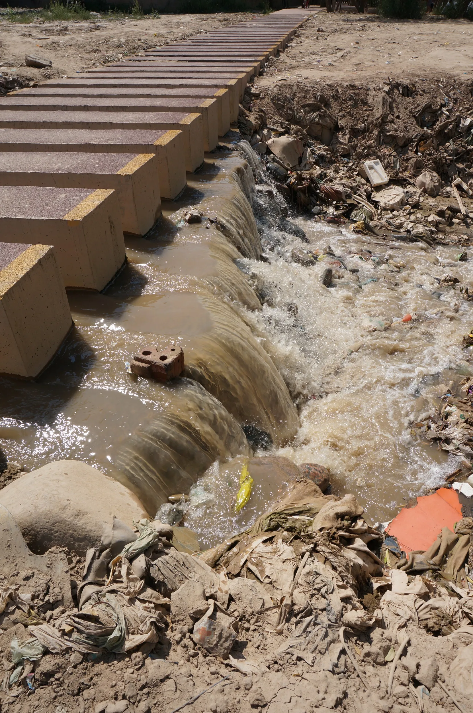 遊歩道を横切り黄河へそそぐ小川