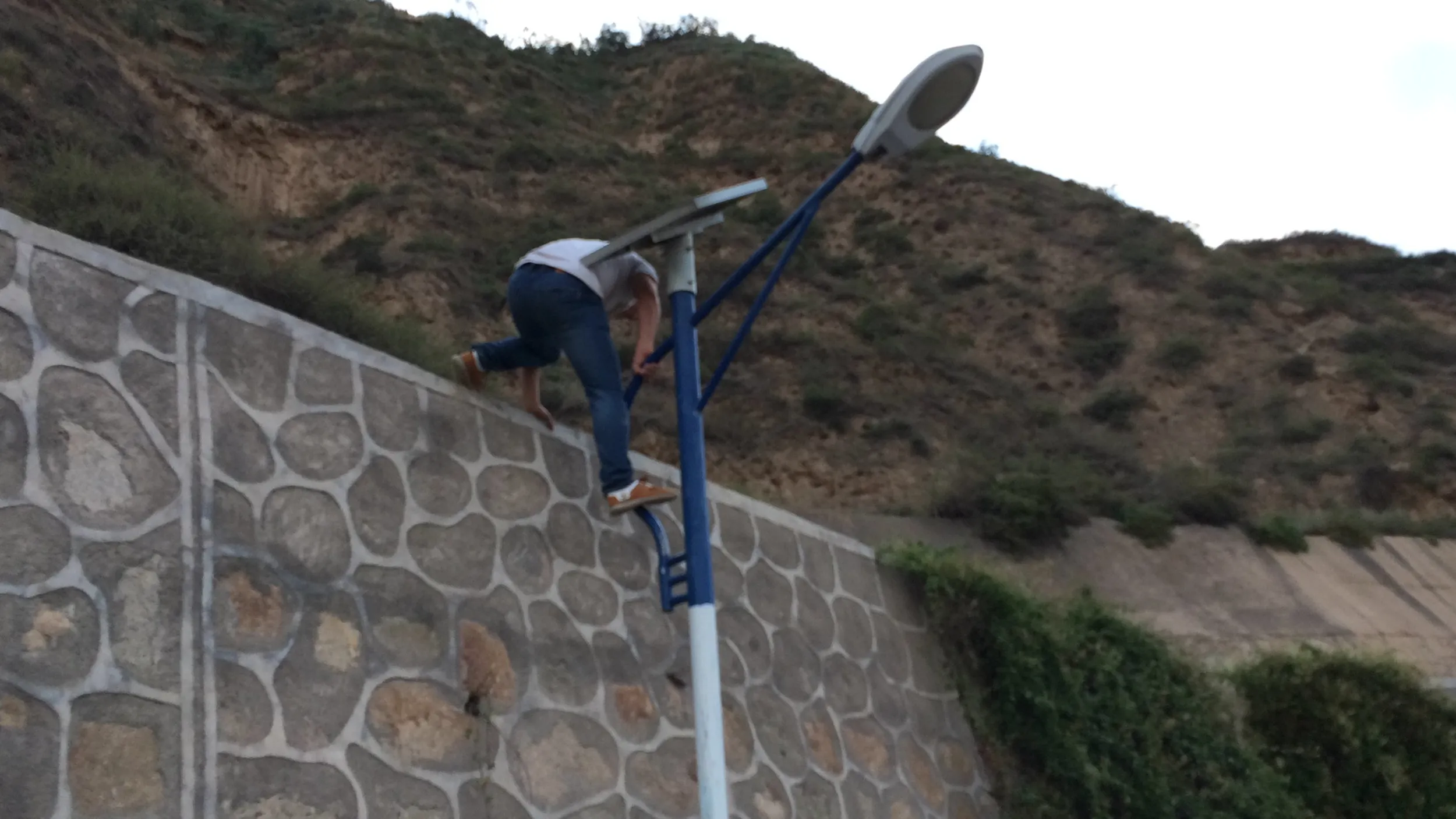 閉ざされた山道を電灯を伝って下山する人