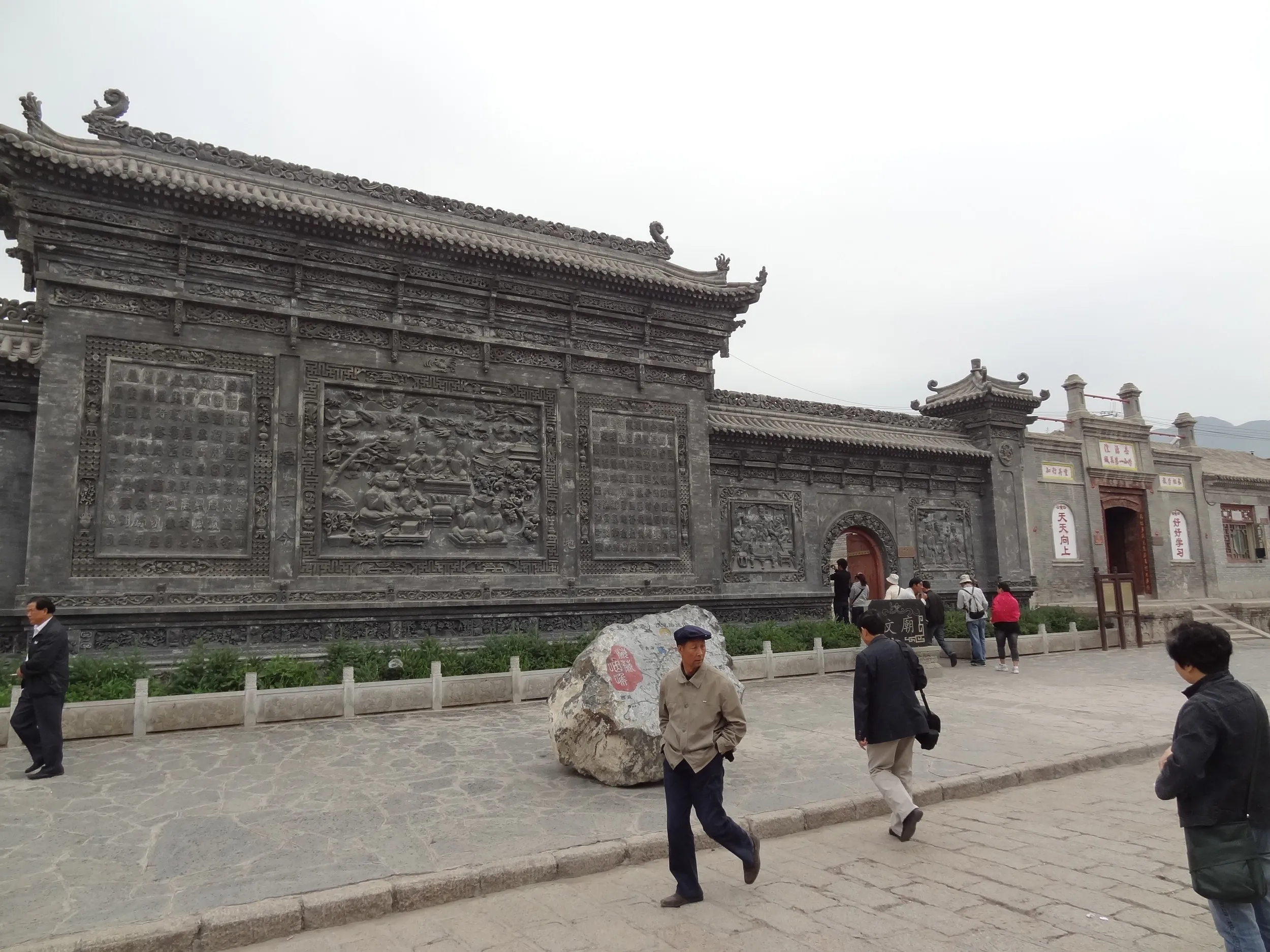 漢字と人物が彫られた壁